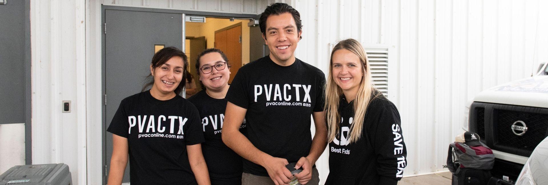 Three women and a man posing for a group photo with shirts using the logo PVACTX